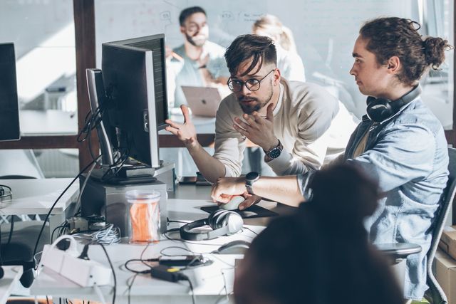 Zwei Programmierer im Büro. Sie diskutieren und arbeiten an einem neuen Projekt.